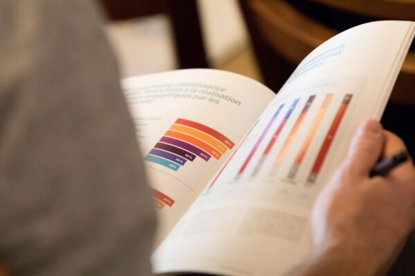 Lecture d'une publication imprimée présentant un graphique en barres, à la maquette éditoriale soignée