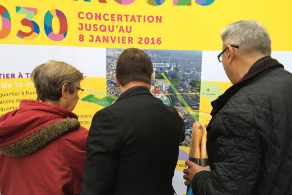 Habitants consultant les panneaux d'information d'une concertation
