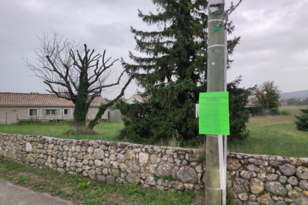 Avis d'enquête publique affiché sur poteau en zone rurale
